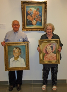 Joyce holding up her paintings with Bennie